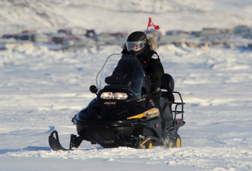 Prime Minister Stephen Harper rides a snowmobile in Frobisher Bay in Iqaluit Nunavut